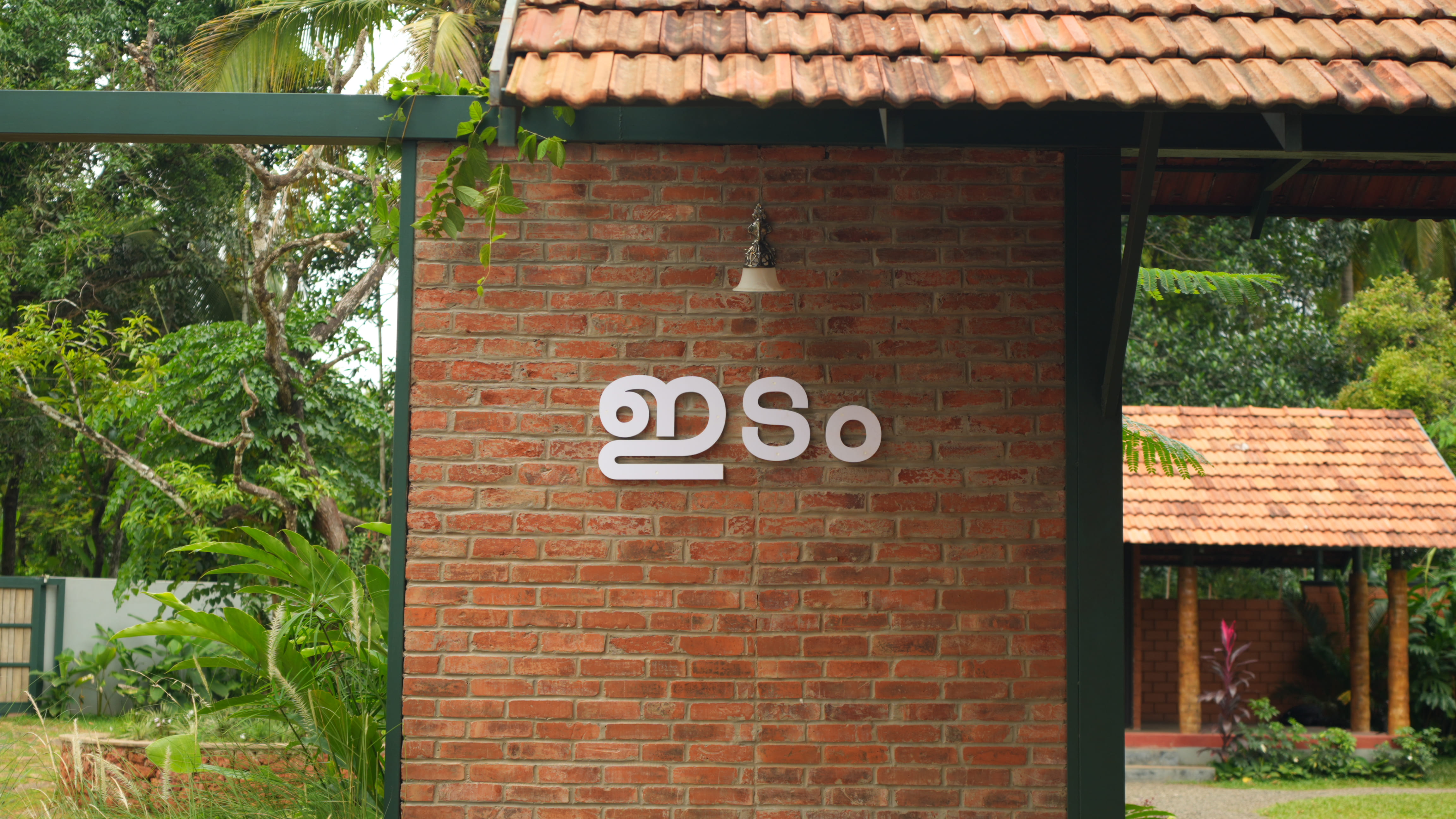 Brick wall with Malayalam lettering at Idam Retreat, a premier intimate wedding location